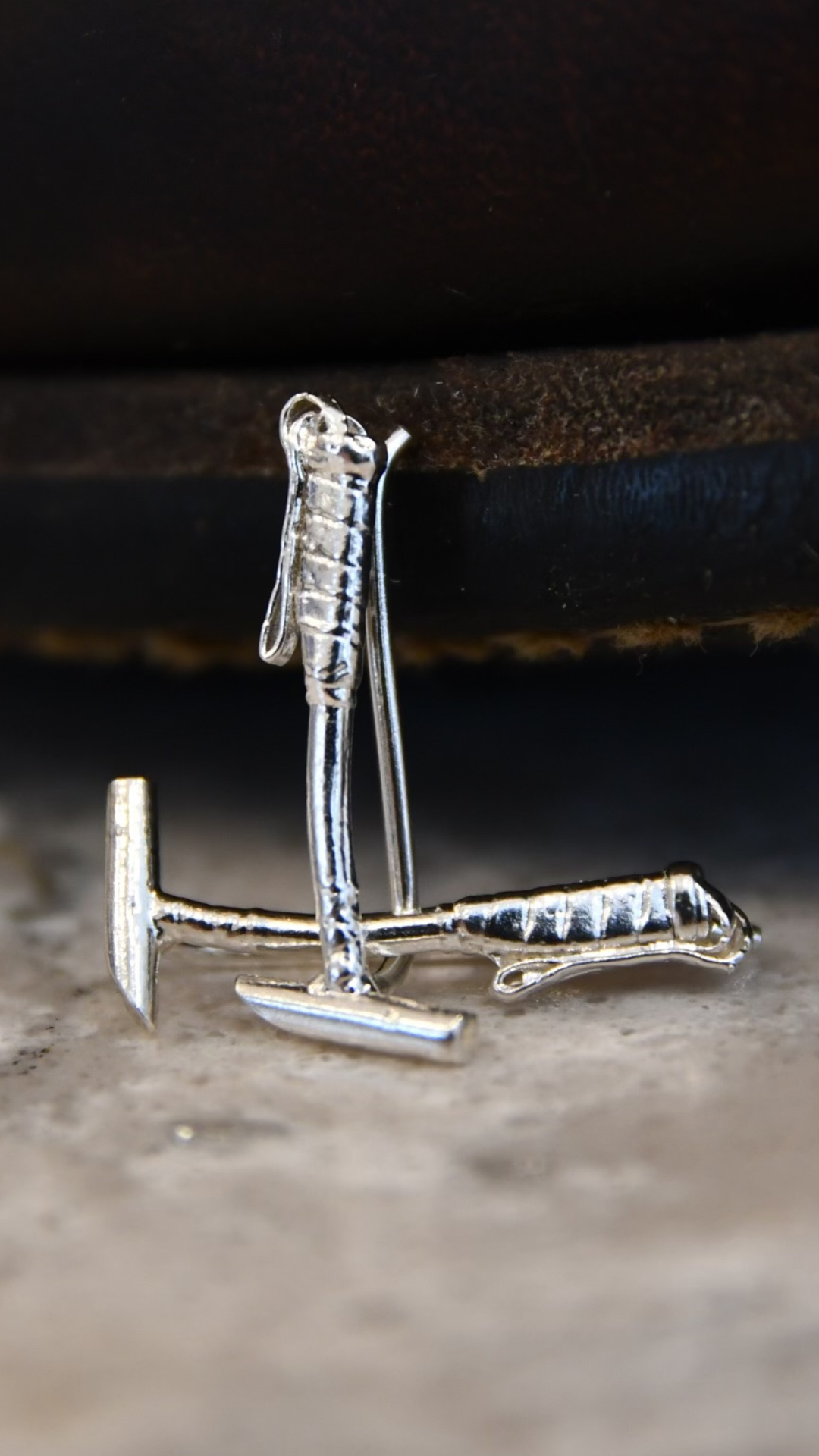 Sterling silver polo mallet earring climbers displayed on a natural stone surface — handcrafted ear climbers designed for polo players and equestrian gifting.