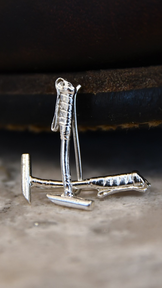 Sterling silver polo mallet earring climbers displayed on a natural stone surface — handcrafted ear climbers designed for polo players and equestrian gifting.